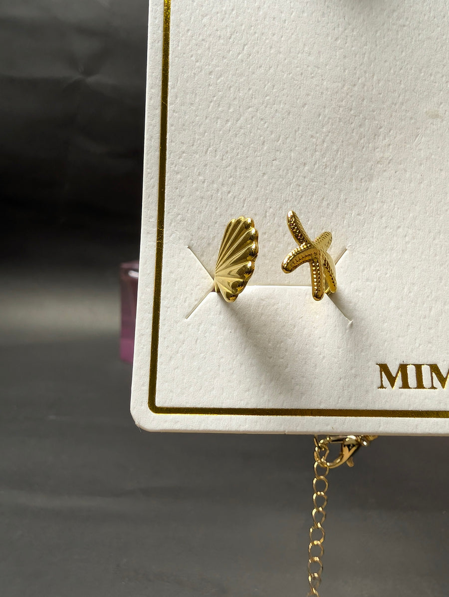 Open ring featuring a textured seashell and a small starfish motif