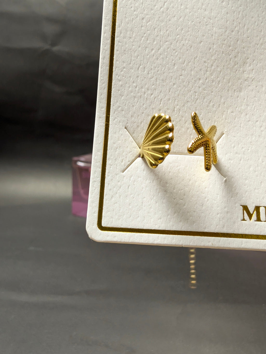 Open ring featuring a textured seashell and a small starfish motif